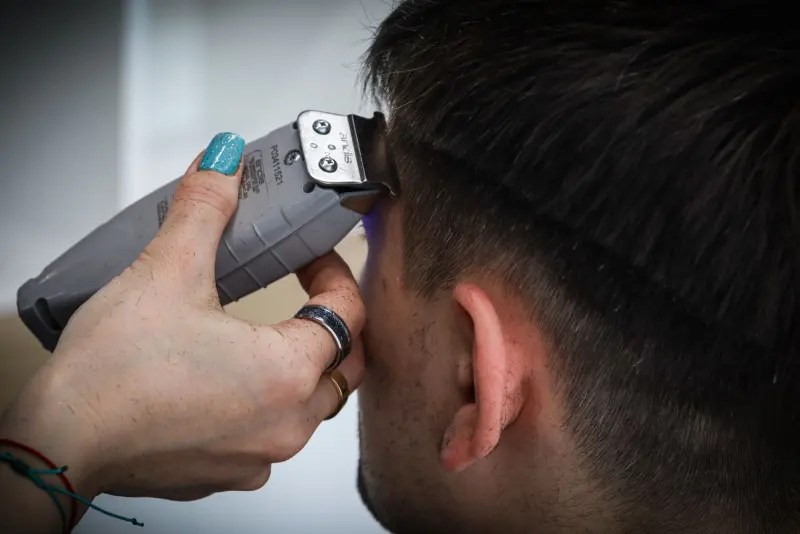 Barbero marcando un low fade con máquina en la nuca